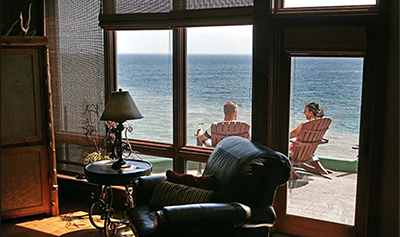 People sitting on their balcony overlooking a lake view.